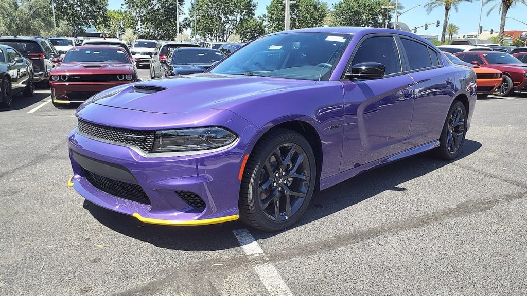 Purple 2023 Dodge Charger R/T with yellow splitter accents parked in dealership lot among other performance vehicles
