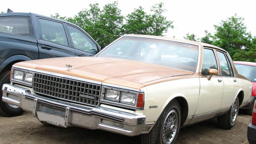 Beige 1980 Chevrolet Caprice Classic with chrome grille and wire wheels parked at outdoor car gathering