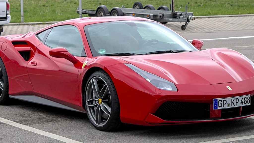  Red Ferrari 488 GTB sports car with distinctive side air intakes parked on street with German license plate