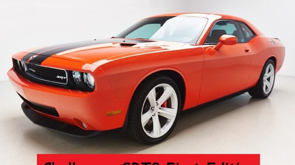 Orange 2008 Dodge Challenger SRT8 with black racing stripes and five-spoke wheels photographed in white studio with partial text visible