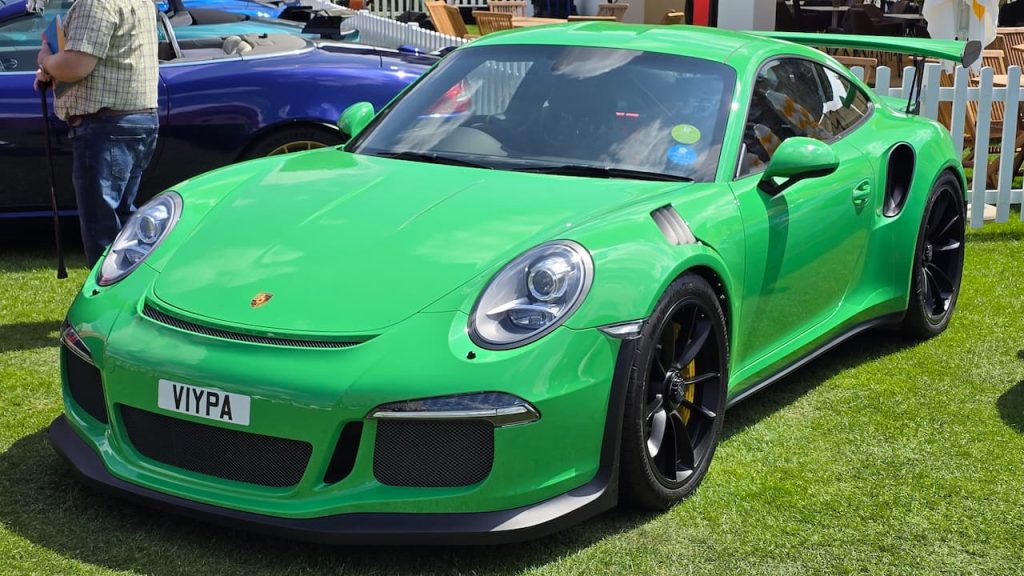 Bright green 2016 Porsche 911 GT3 RS sports car with black wheels and carbon fiber details at outdoor car show