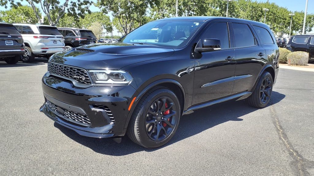 Black 2023 Dodge Durango SRT parked in dealership lot with red brake calipers, sport wheels, and aggressive front bumper styling