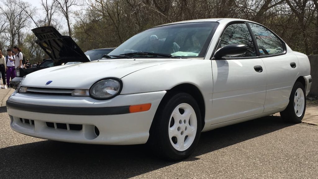 White Neon ACR with hood open and white wheels displayed at outdoor car show event