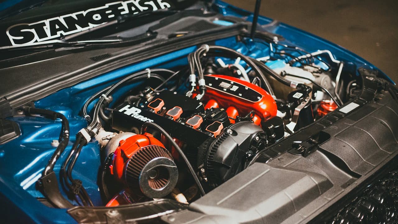 Modified blue car engine bay featuring custom turbo setup with Nitrous Oxide injection system and performance aftermarket components installed