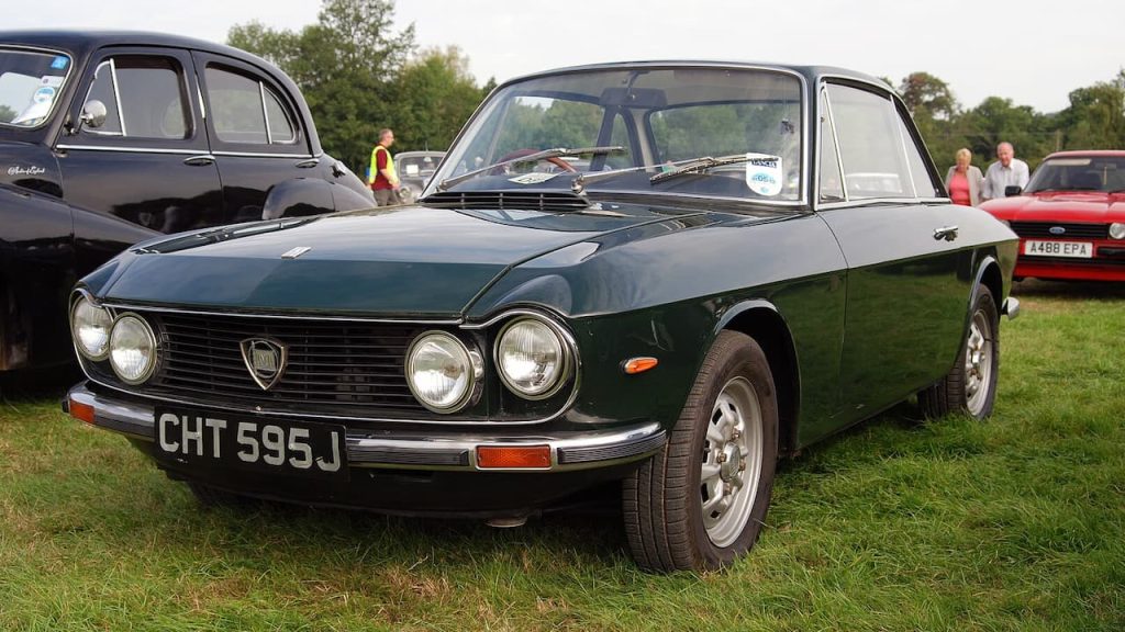 Black Lancia Fulvia with registration CHT595J at classic car show on grass with spectators and vintage cars