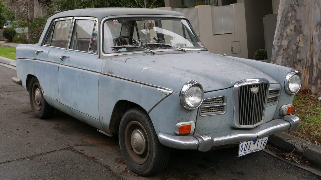 Light blue vintage 1964 Wolseley 24/80 sedan with chrome bumpers and grille parked on residential street